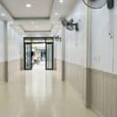 Lamri nhựa giả gỗ Nano NT01 vân sồi trắng kem wainscoting cả 2 bên hành lang PVC trắng nẹp vàng gold panel sàn gạch ceramic kem trắng nhà phố thương mại TP.HCM