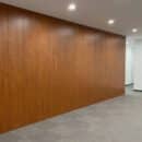 Ốp tường nhựa Nano FX237 vân gỗ teak nâu đỏ toàn bộ mặt tường lớn văn phòng hành lang phong cách Modern Office trần downlight sàn thảm xám TP.HCM