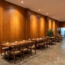 Ốp tường nhựa Nano NA203 vân gỗ teak nâu vàng ấm nhà hàng Vietnamese Modern phào cổ trần downlight hắt sáng dãy bàn ăn gỗ sàn bê tông mài TP.HCM