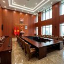 Vách lam nhựa giả gỗ 4S36 màu gỗ đỏ nâu ốp tường phòng họp cơ quan nhà nước bàn họp chữ U ghế da nâu cờ Tổ quốc TP.HCM
